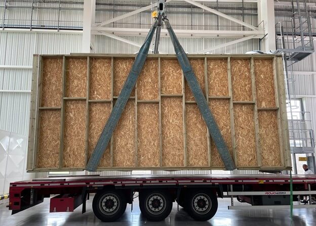 wooden wall frame being loaded onto a trailer